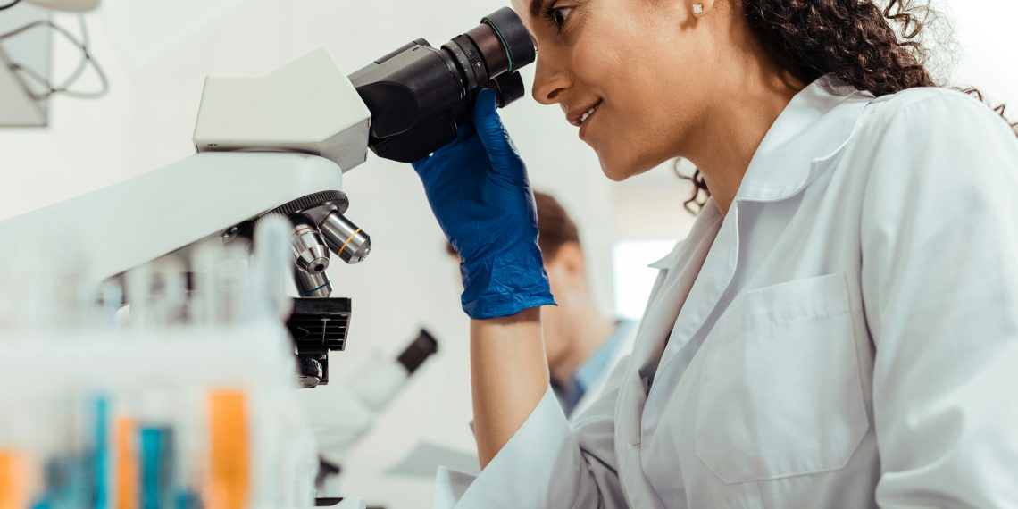 Wissenschaftlerin schaut in Mikroskop (Foto: Unsplash/Getty Images)