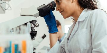 Wissenschaftlerin schaut in Mikroskop (Foto: Unsplash/Getty Images)