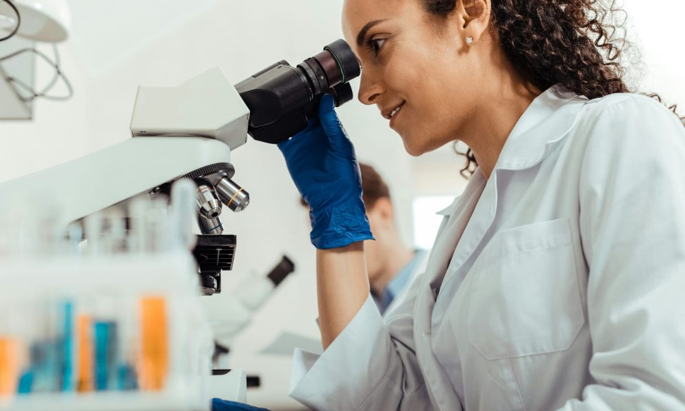 Wissenschaftlerin schaut in Mikroskop (Foto: Unsplash/Getty Images)