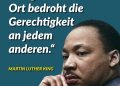 Der Bürgerrechtler und bekennende demokratische Sozialist Martin Luther King Jr. veränderte mit seinem Kampf gegen Rassismus und soziale Ungleichheit nicht nur die Vereinigten Staaten, sondern prägte eine weltweite Bewegung. Er setzte sich für die Gleichberechtigung aller Menschen ein und stellte sich ebenso gegen ökonomische Ungleichheit. Sein Prinzip des gewaltfreien Widerstands trug maßgeblich zum Ende der Rassentrennung in den USA bei und inspiriert bis heute Millionen Menschen weltweit. Am 4. April 1968 wurde Martin Luther King Jr. aufgrund seiner Überzeugungen ermordet. Die Umstände seines Todes sind bis heute nicht vollständig aufgeklärt. Zitat: Ungerechtigkeit an irgendeinem Ort bedroht die Gerechtigkeit an jedem anderen. Martin Luther King