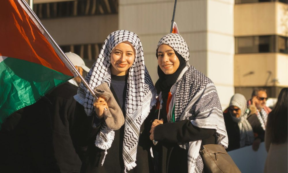 Zwei Frauen mit palästinensischer Flagge. Foto: unsplash/tristan-sosteric