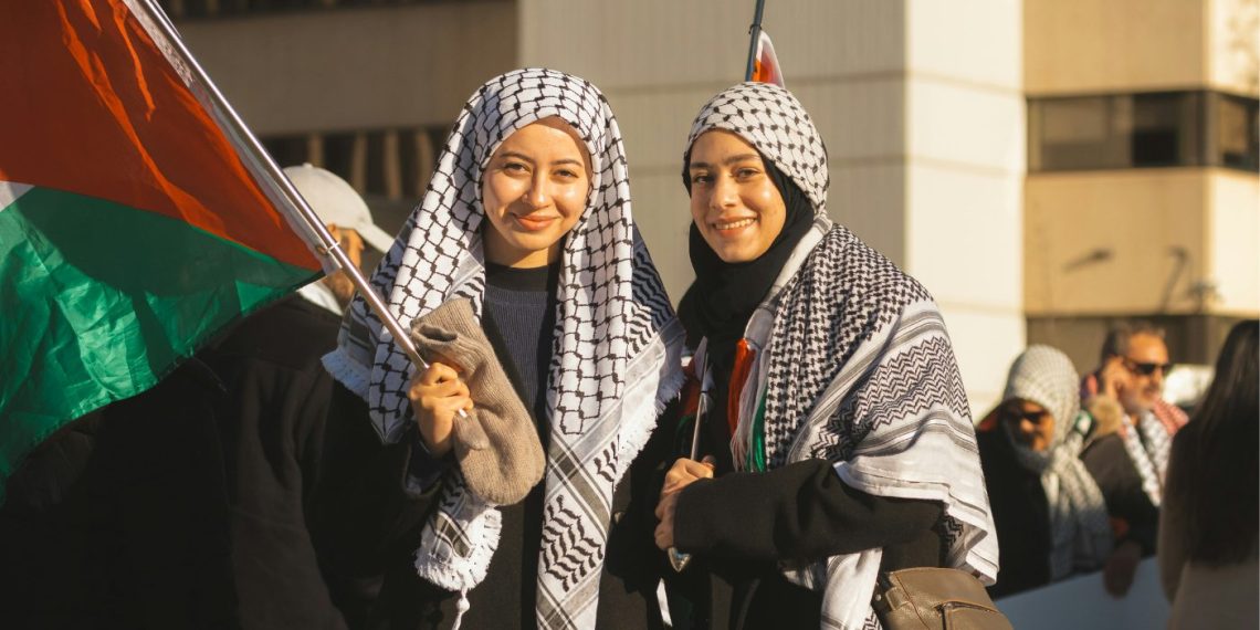 Zwei Frauen mit palästinensischer Flagge. Foto: unsplash/tristan-sosteric