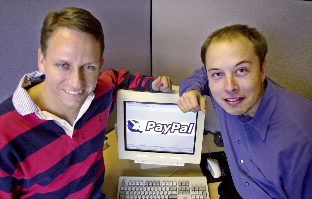 Teil von Peter Thiels Biorafie: Elon Musk. FILE - PayPal Chief Executive Officer Peter Thiel, left, and founder Elon Musk, right, pose with the PayPal logo at corporate headquarters in Palo Alto, Calif., Oct. 20, 2000. (AP Photo/Paul Sakuma)