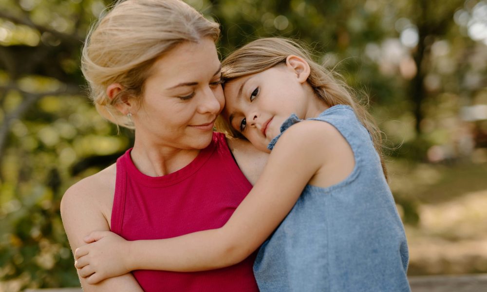 Mutter mit Kind im Arm im Park. (Foto: Unsplash)