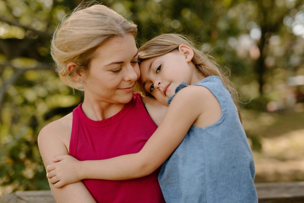 Mutter mit Kind im Arm im Park. (Foto: Unsplash)