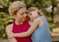 Mutter mit Kind im Arm im Park. (Foto: Unsplash)