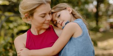 Mutter mit Kind im Arm im Park. (Foto: Unsplash)