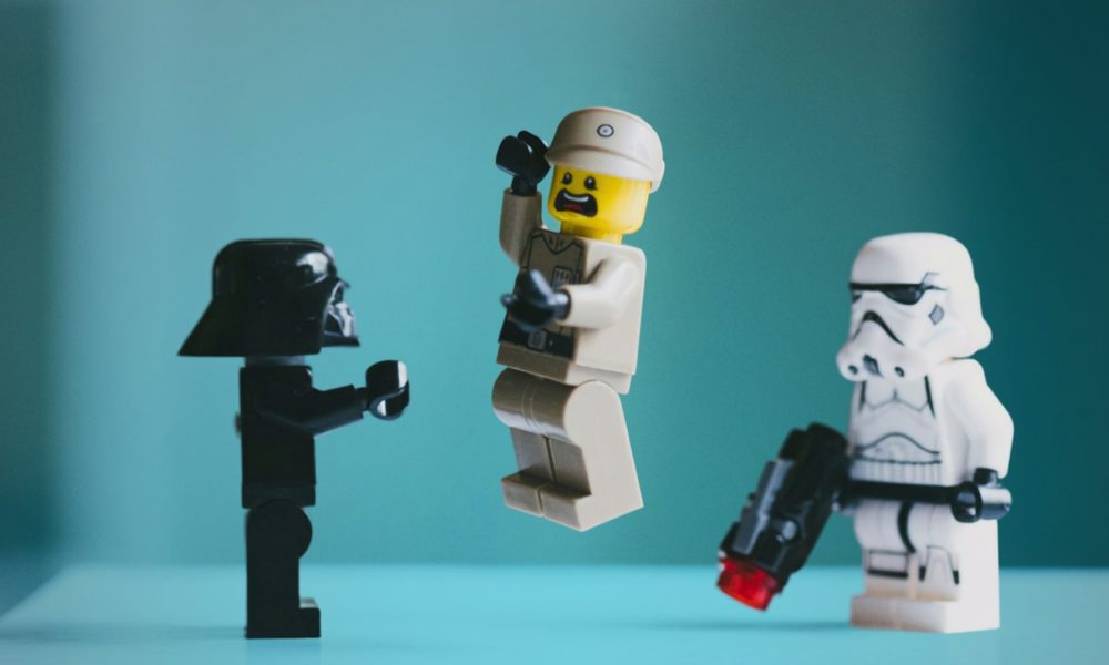 LEGO-Minifiguren in einer Szene vor türkisfarbenem Hintergrund. LEGO-/Star-Wars-Minifiguren. Foto: Daniel Cheung via unsplash