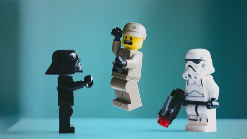 LEGO-Minifiguren in einer Szene vor türkisfarbenem Hintergrund. LEGO-/Star-Wars-Minifiguren. Foto: Daniel Cheung via unsplash