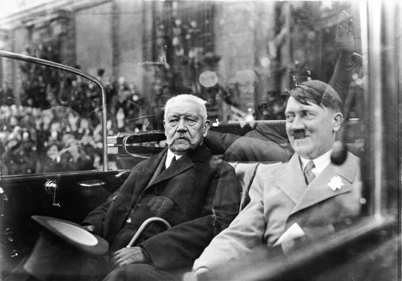 Nach der Weltwirtschaftskrise zerbrachen stabile Mehrheiten im Reichstag, Präsidialkabinette regierten zunehmend per Notverordnung. Die NSDAP wurde 1932 stärkste Partei, Hitler blieb zunächst dennoch ohne Kanzleramt. Die Regierung unter Franz von Papen scheiterte an einem Misstrauensvotum des Parlaments. Sein Nachfolger Kurt von Schleicher verlor Hindenburgs Rückhalt, nachdem seine Pläne für einen autoritären Machterhalt und eine Spaltung der NSDAP gescheitert waren. Am 30. Januar 1933 ernannte Reichspräsident Paul von Hindenburg den damaligen NSDAP-"Führer" Adolf Hitler zum deutschen Reichskanzler (Foto: Bundesarchiv, Bild 102-14569 / Wikipedia/ CC BY-SA 3.0 de (Link https://creativecommons.org/licenses/by-sa/3.0/de/deed.en)