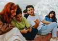 Neue KI-Verordnung will es leichter machen, KI zu erkennen. (Bild: Junge Menschen sitzen an Straßenrand mit Smartphones; Foto: Unsplash)